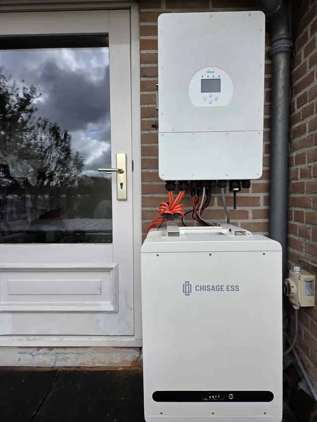 Deye inverter on the brick wall next to the back door, with a Chisage ESS battery below.