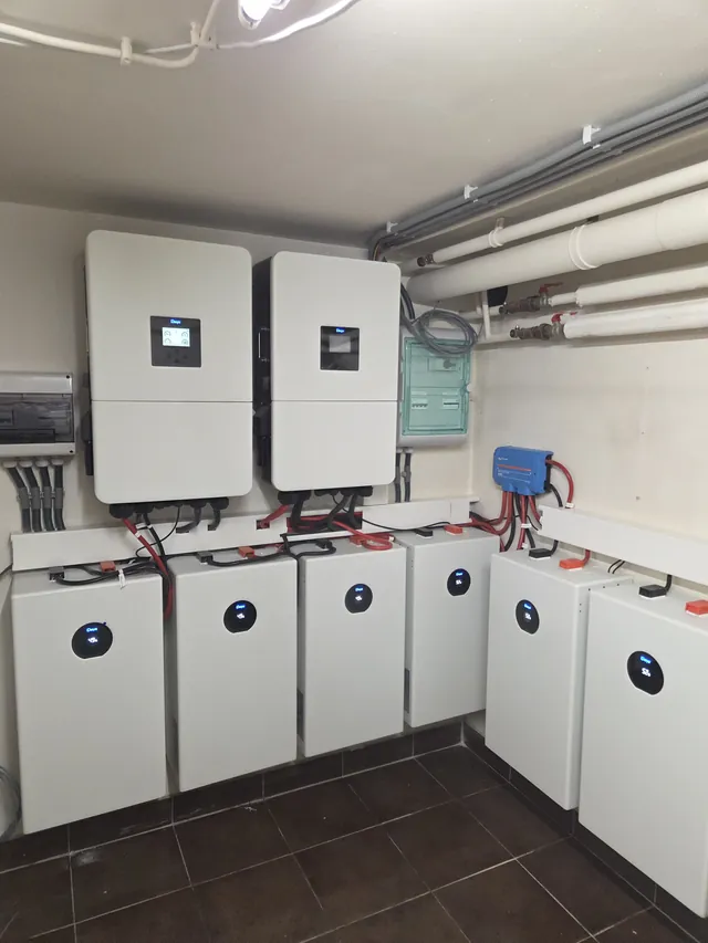 Two Deye inverters in a plant room, with six battery modules along two walls.