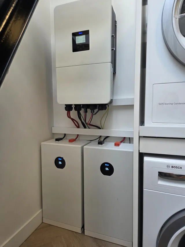 Deye inverter next to the washing machine and dryer, with two battery modules below.
